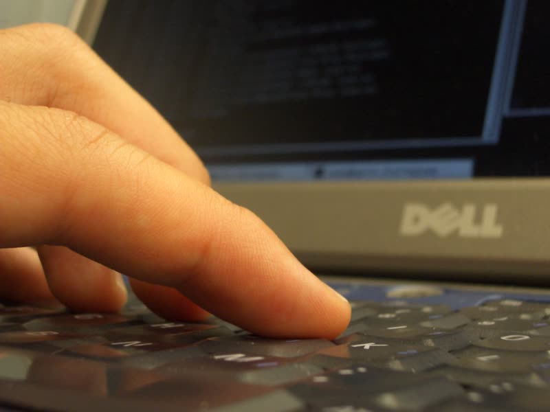 Dedo presionando una tecla de un teclado de computadora