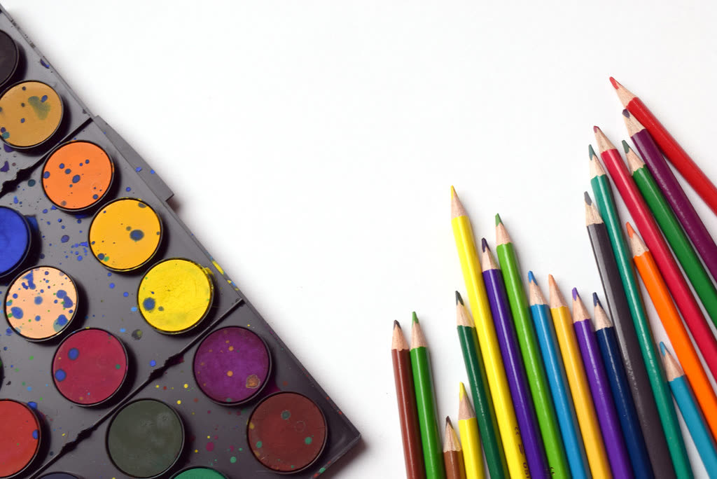 Materiales de acuarela y lápices de colores listos para un taller de arte infantil
