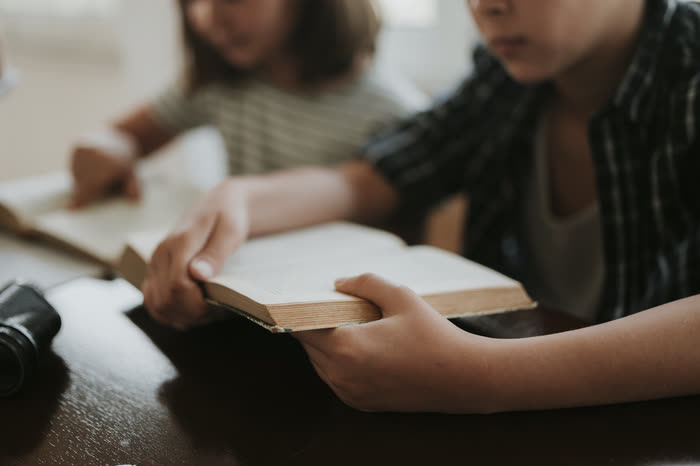 Niños leyendo juntos un libro en el club de lectura