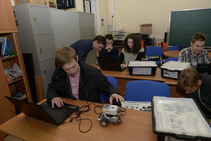 Estudiantes armando un robot programable en el laboratorio de robótica