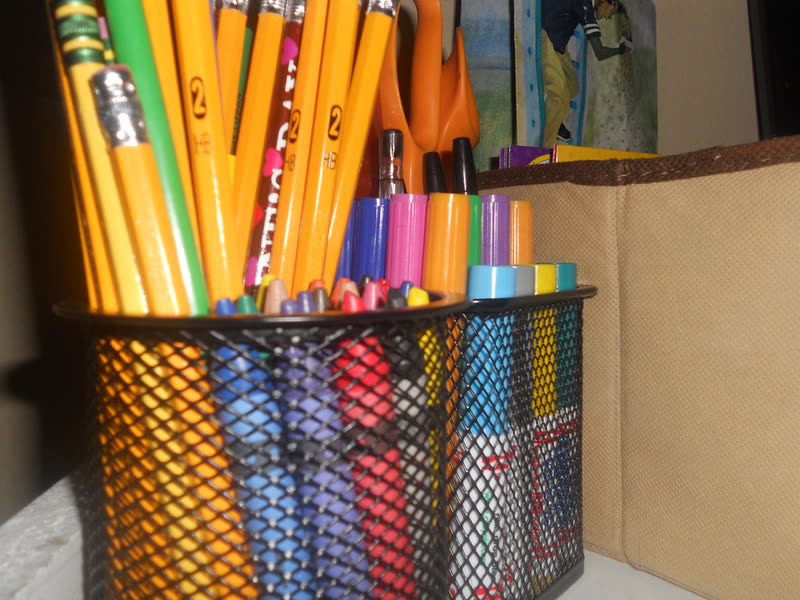 Lápices y plumones de colores organizados en botes