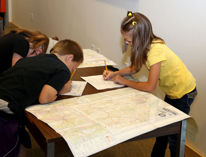 Niños trabajando en un proyecto de mapas y mediciones sobre una mesa